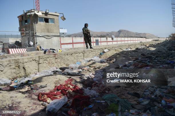 Taliban fighter stands guard at the site of the August 26 twin suicide bombs, which killed scores of people including 13 US troops, at Kabul airport...