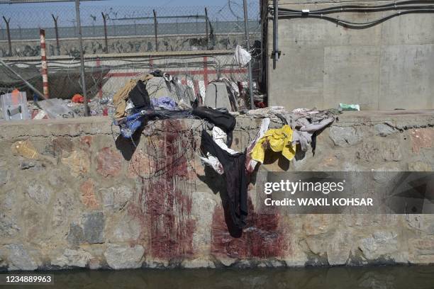 Clothes and blood stains of Afghan people who were waiting to be evacuated are seen at the site of the August 26 twin suicide bombs, which killed...