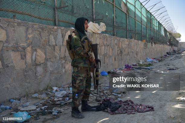 Taliban fighter stands guard at the site of the August 26 twin suicide bombs, which killed scores of people including 13 US troops, at Kabul airport...