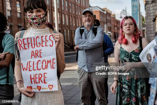 Protester holds a placard during the demonstration. Dozens of people gathered in front of Ireland's parliament building, Leinster House, to demand...