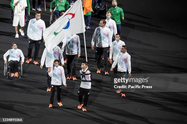 Members of Refugee team walk with their national flag on the stadium as part of parade of athletes Tokyo 2020 Paralympic Games opening ceremony on...
