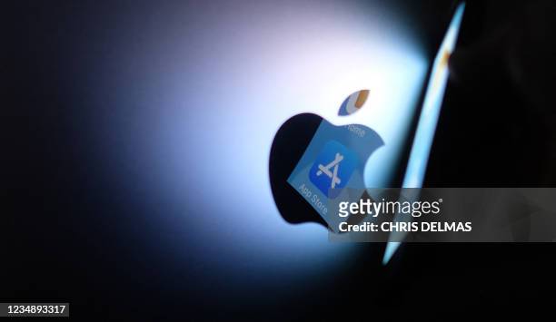 This illustration photo shows the Apple app store logo reflected from an iPhone onto the back of an iMac in Los Angeles, August 26, 2021. - Apple has...