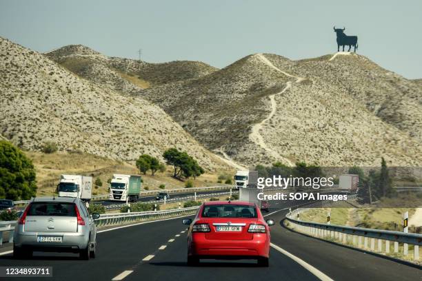 The black silhouette of an Osborne bull on one side of the National in Alfajarin. The Osborne bull since 1956 it is an icon of the roads of Spain....