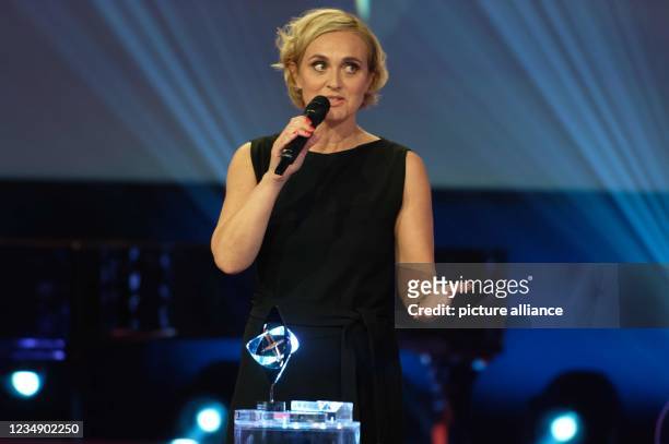 August 2021, North Rhine-Westphalia, Marl: Presenter Caren Miosga is on stage at the 57th Grimme Awards ceremony with the award in the category...