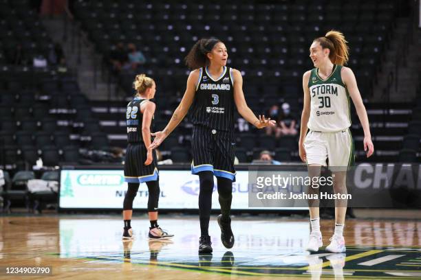 Candace Parker of the Chicago Sky laughs with Breanna Stewart of the Seattle Storm during the game on August 27, 2021 at the Angel of the Winds...