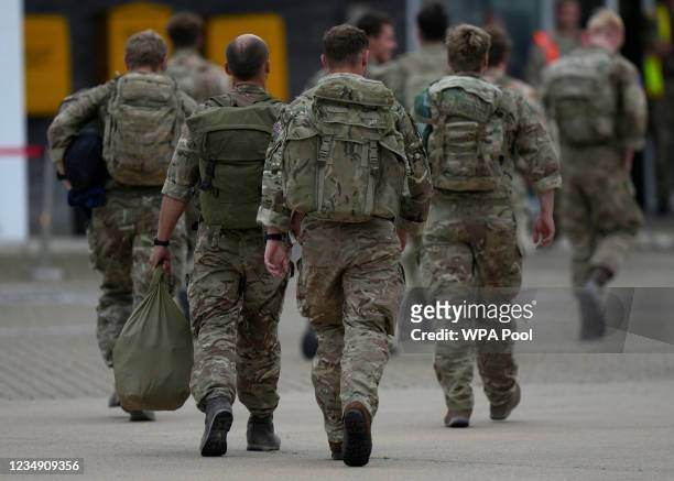Members of the British armed forces 16 Air Assault Brigade walk to the air terminal after disembarking a Royal Airforce Voyager aircraft at Brize...