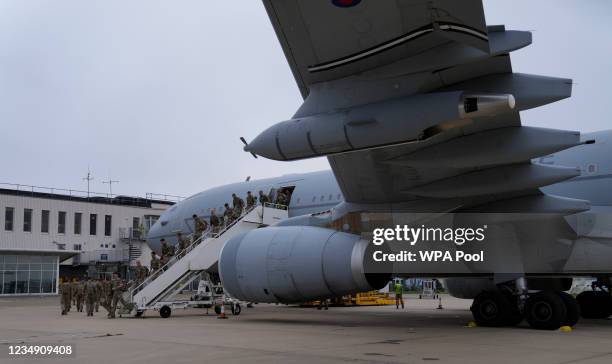 Members of the British armed forces 16 Air Assault Brigade walk to the air terminal after disembarking a RAF Voyager aircraft at Brize Norton as they...