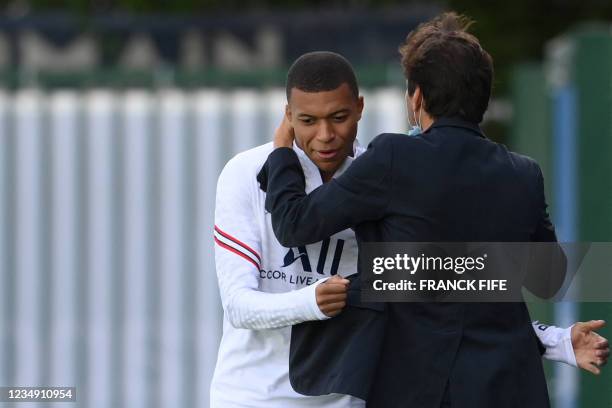 Paris Saint-Germain's Brazilian sporting director Leonardo embraces Paris Saint-Germain's French forward Kylian Mbappe prior to a training session at...