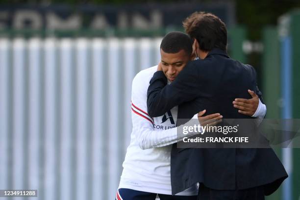 Paris Saint-Germain's Brazilian sporting director Leonardo embraces Paris Saint-Germain's French forward Kylian Mbappe prior to a training session at...