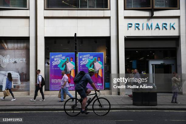 Pedestrians walk past a poster advertising in-store vaccinations at Primark on Oxford Street on August 28, 2021 in London, England. Primark is...