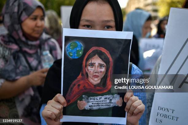 Protester holds a placard during a demonstration of members of the Afghan community outside the US embassy in Athens after the Taliban swept to power...