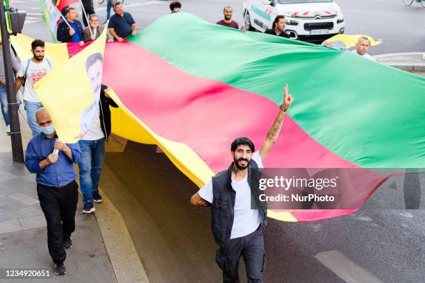 Kurdish demonstrators carry a long flag in the colors of Kurdistan in Paris, France, on August 28, 2021. As the French and Iraqi presidents organize...