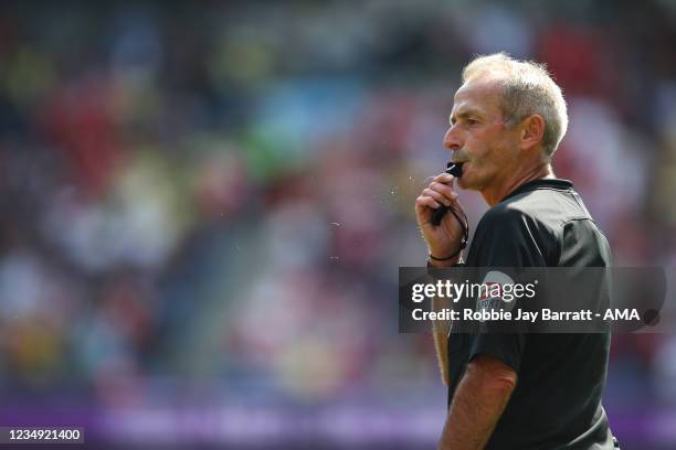 Referee Martin Atkinson blows his whistle during the Premier League match between Manchester City and Arsenal at Etihad Stadium on August 28, 2021 in...