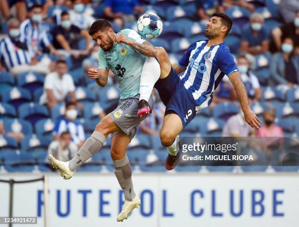 Arouca's Brazilian defender Thales jumps for the ball with FC Porto's Iranian forward Mehdi Taremi during the Portuguese League football match...