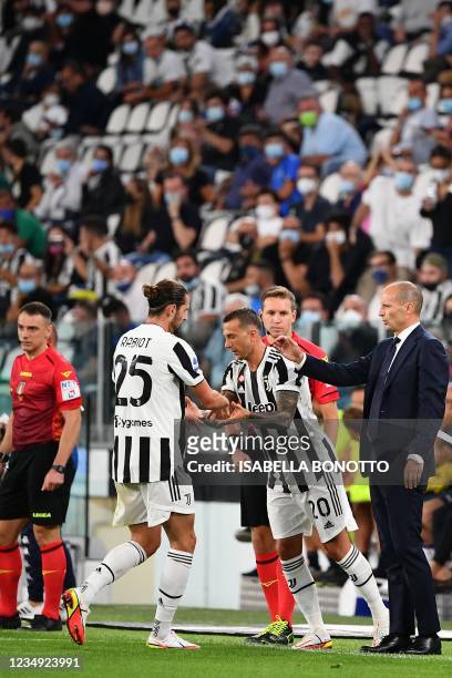Juventus' Italian head coach Massimiliano Allegri welcomes Juventus' French midfielder Adrien Rabiot as Juventus' Italian midfielder Federico...