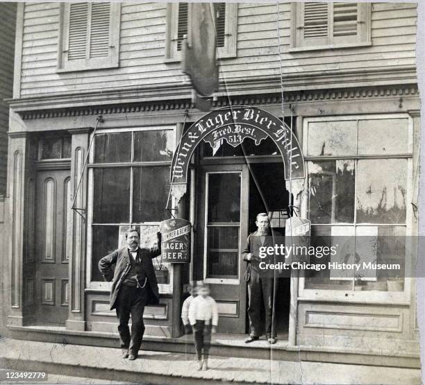 Two men and a little boy stand outside the Wein & Lager Bier Halle, located at 513 South Halsted Street, in Chicago, IL, 1883.