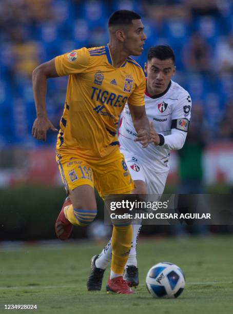 Tigres' David Ayala and Atlas' Aldo Rocha vie for the ball during their Mexican Apertura 2021 tournament football match at the Universitario stadium...