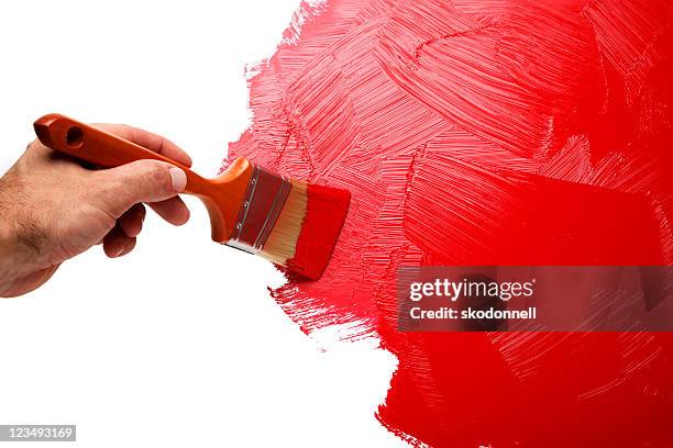 painting the wall with red paint - hands painting stock pictures, royalty-free photos & images