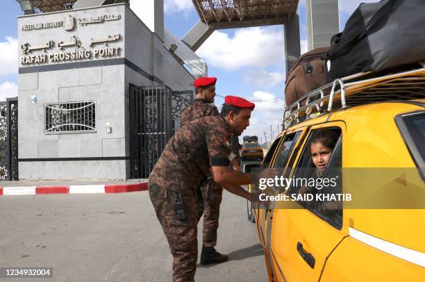 Palestinian girl looks out a taxi window as she crosses with relatives into Egypt through the Rafah border crossing from the Gaza Strip on August 29,...