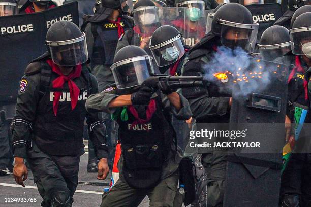 Riot policeman fires rubber bullets as protesters take part in a demonstration calling for the resignation of Thailand's Prime Minister Prayut...
