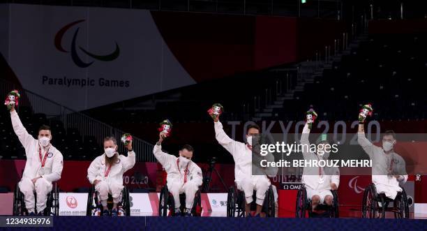 Silver medallists USA pose on the podium during the medal ceremony of the wheelchair rugby event during the Tokyo 2020 Paralympic Games at the Yoyogi...