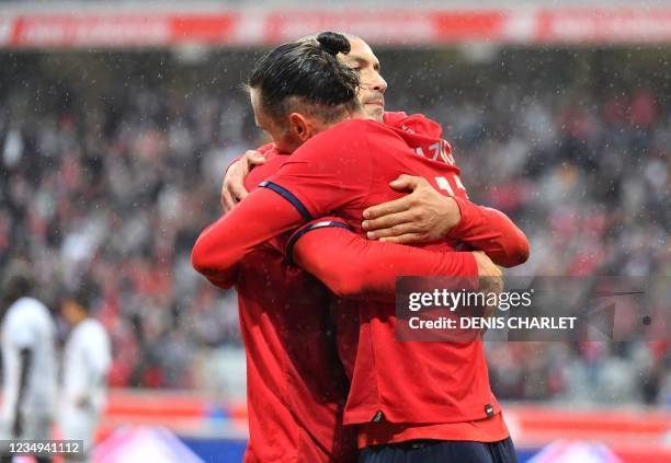 Lille's midfielder Yusuf Yazici celebrates with Lille's forward Burak Yilmaz after he scored a first goal during the French L1 football match between...