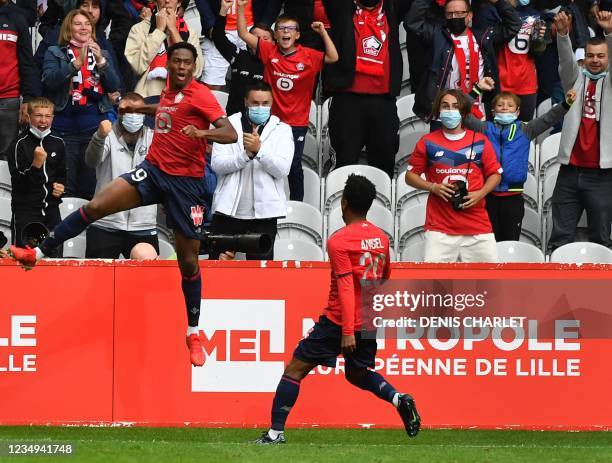 Lille's French forward Jonathan David and Lille's midfielder Angel Gomes celebrate a goal during the French L1 football match between Lille OSC and...