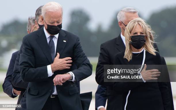 AUS President Joe Biden looks down alongside First Lady Jill Biden as they attend the dignified transfer of the remains of a fallen service member at...