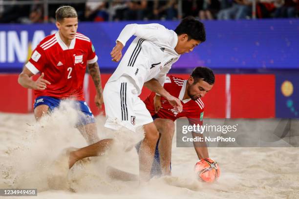 Ryunosuke Miyama of Japan vies for the ball with Aleksey Makarov and Andrei Novikov of Football Union Of Russia during the FIFA Beach Soccer World...