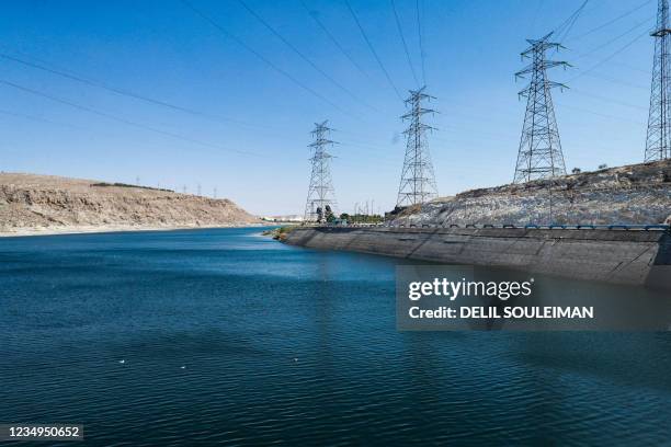 This picture taken on July 24, 2021 shows a view of the high voltage electricity transmission towers connecting to the 1999 Tishrin Dam along the...