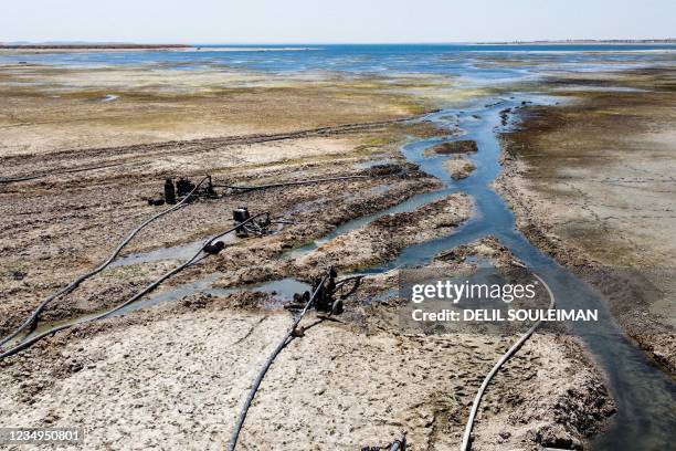 This picture taken on July 27, 2021 shows an aerial view of water pumps drawing water from the Lake Assad reservoir , in the village of al-Tuwayhinah...