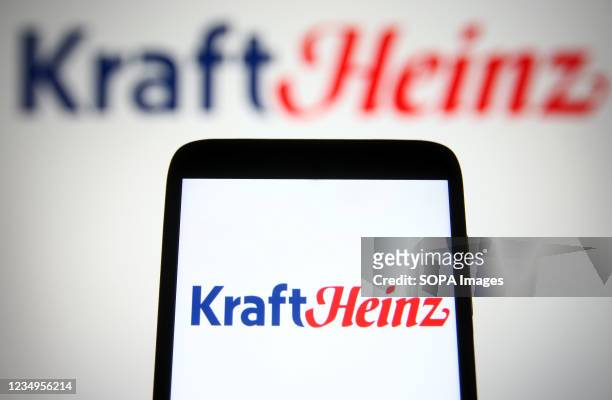 In this photo illustration, Kraft Heinz Company logo is seen on a smartphone and a pc screen.