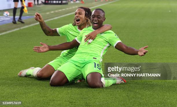 Wolfsburg's French defender Jerome Roussillon celebrates scoring the opening goal with his teammate Wolfsburg's Swiss defender Kevin Mbabu during the...