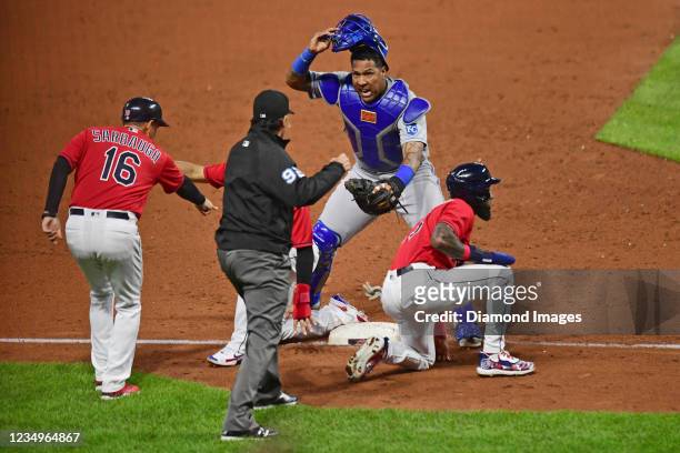 Salvador Perez of the Kansas City Royals pleads his case for tagging out Daniel Johnson and Cesar Hernandez of the Cleveland Indians, as third base...