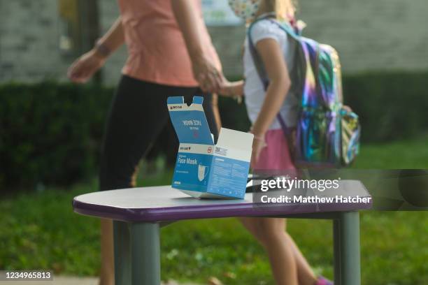 Face masks sit on a table outside of Schoolcraft Elementary for students and parents to wear when entering the building on the first day of school on...