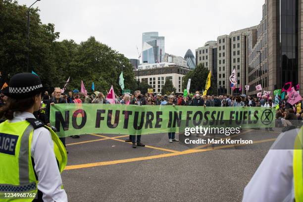 Environmental activists from Extinction Rebellion block the Tower Gateway one-way system during an Impossible Tea Party event on 30th August 2021 in...