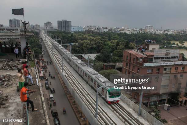 Aerial view of people during the first formal trial ride on the overpass tracks of Bangladesh's first-ever metro rail train in Mirpur area on Sunday....