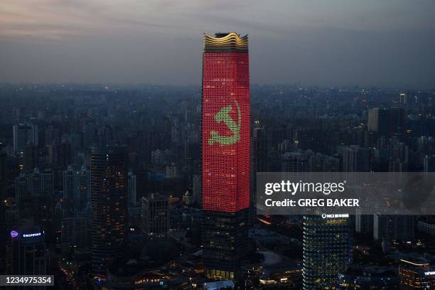 The Communist Party logo is seen on a skyscraper in Shanghai at dusk on August 31 part of celebrations marking the 100th anniversary of the founding...