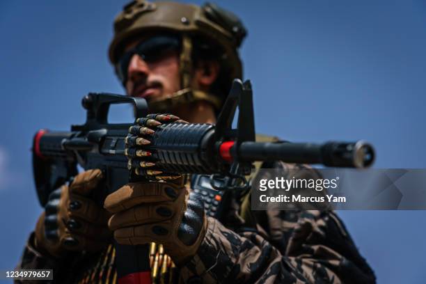 Taliban fighter stands ready with his rifle in as the militant group secure the Hamid Karzai International Airport, in the wake of the American...