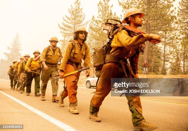Forest Service firefighter crew arrives at the scene where flames from the Caldor fire threaten to jump highway 50 in Meyers, California on August...