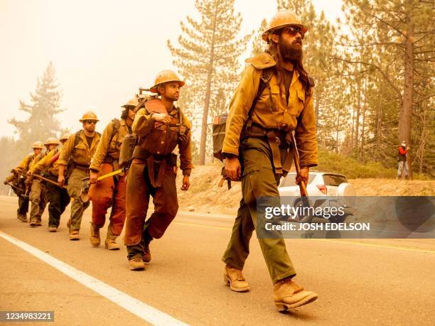 Forest Service firefighter crew arrives at the scene where flames from the Caldor fire threaten to jump highway 50 in Meyers, California on August...