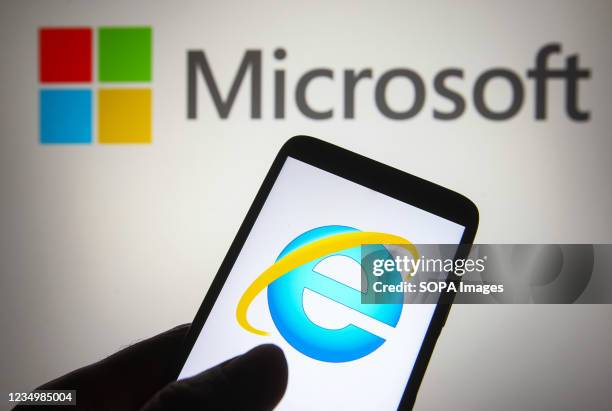 In this photo illustration an Internet Explorer logo is seen on a smartphone with a Microsoft logo in the background.