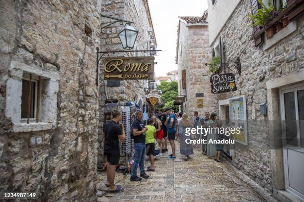 People walk at street in Budva town of Montenegro on August 31, 2021. Montenegro attracts tourists with its sea, mountains, lakes, caves, waterfalls...