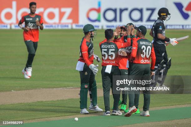 Bangladesh's cricketers celebrate after the dismissal of New Zealand's Rachin Ravindra during the first Twenty20 international cricket match between...