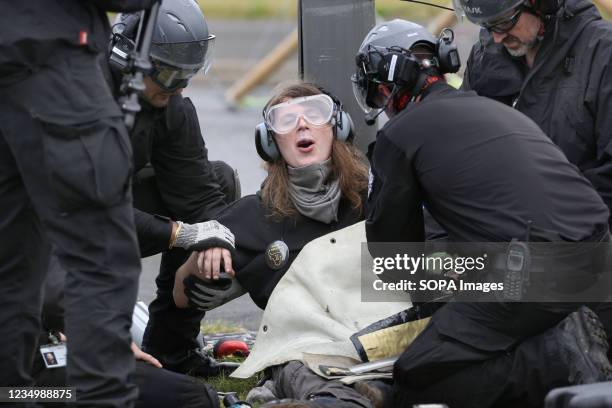 Protester's hands are released from tubing by police as 50 Animal Rebels shut-down Arla's main dairy factory in Aylesbury by blockading the entrance...