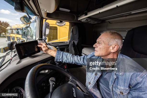 Driver adjusts a satellite navigation unit in a truck cab at the Waberer's International Zrt. Headquarters in Budapest, Hungary, on Tuesday, Aug. 31,...