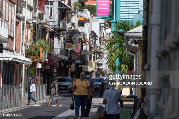 Bystanders stroll in the streets during a strict lockdown due to the Covid 19 in the city of Fort-de-France, in the French Caribbean island of...