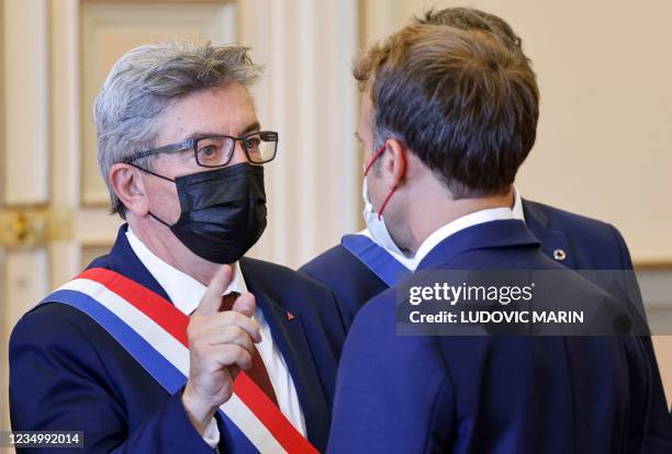 French President Emmanuel Macron speaks with French far-left La France Insoumise parliamentary group's president Jean-Luc Melenchon as he arrives at...