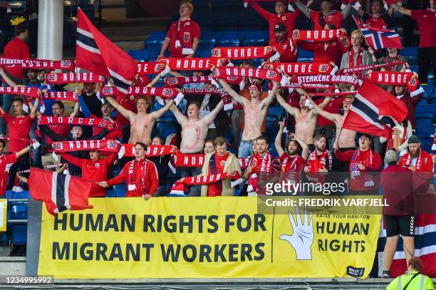 Banner in support for migrant workers is seen as fans cheer prior to the World Cup qualifier football match between Norway and the Netherlands at...