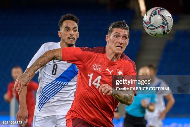 Greece's midfielder Jose Carlos Goncalves Rodrigues and Switzerland's midfielder Steven Zuber fight for the ball during a friendly football match...